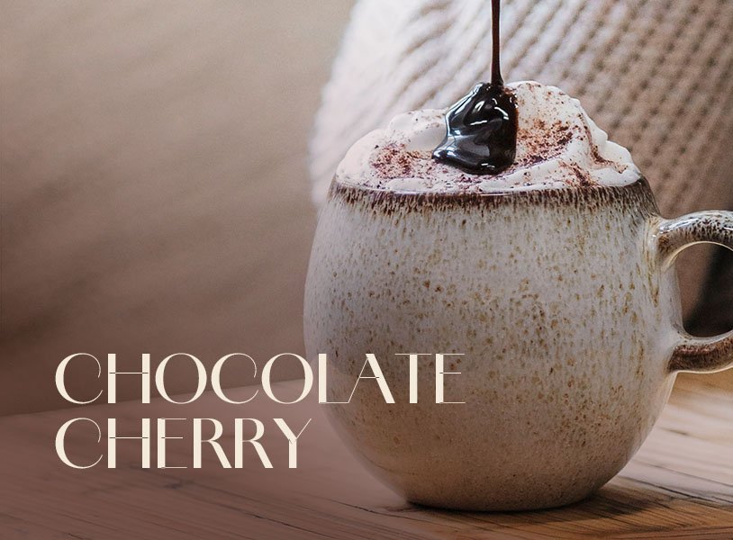 Glas mit ECKES Eclipse Cocktail, garniert mit einer Kirsche, vor einem dunklen Hintergrund