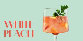 Ein erfrischender Cocktail in einem eleganten Glas, gefüllt mit Pfirsichstücken und einem Minzblatt als Garnitur.