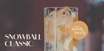 Ein elegantes Glas mit einem erfrischenden Getränk, gefüllt mit Eiswürfeln und einer goldenen Flüssigkeit.