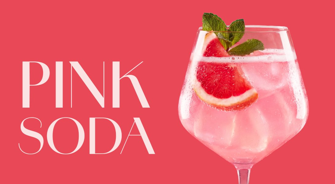 Ein stilvolles Getränk in einem großen Glas, gefüllt mit sprudelndem pinkem Getränk und dekoriert mit einer Grapefruit-Scheibe.