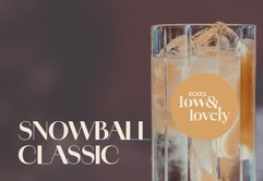 Ein elegantes Glas mit einem erfrischenden Getränk, gefüllt mit Eiswürfeln und einer goldenen Flüssigkeit.