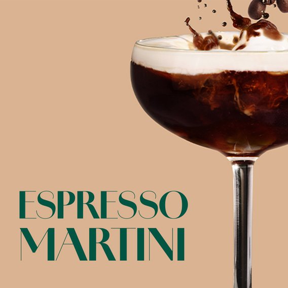 Ein Espresso Martini in einem Glas mit cremigem Schaum und Kaffeebohnen-Deko, elegant serviert.