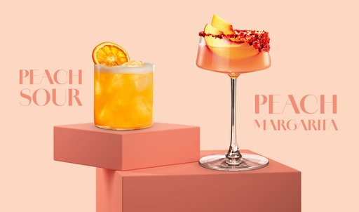 Zwei Cocktails stehen auf einer rosa Plattform: ein Peach Sour mit einer Orangenscheibe und eine Peach Margarita mit Pfirsichstücken.