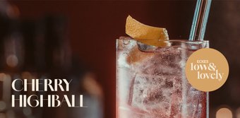 Ein köstlicher Cherry Highball, der mit Eis gefüllt ist und eine frische Zitronenscheibe als Dekoration hat.