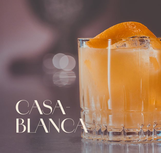 Glas mit ECKES Casablanca Cocktail auf Eis, garniert mit einer Orangenschale