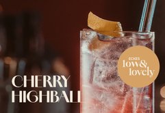 Ein köstlicher Cherry Highball, der mit Eis gefüllt ist und eine frische Zitronenscheibe als Dekoration hat.