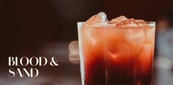 Der Cocktail 'Blood and Sand' in einem hohen Glas, gefüllt mit Eis und einer ansprechenden rot-braunen Farbe.