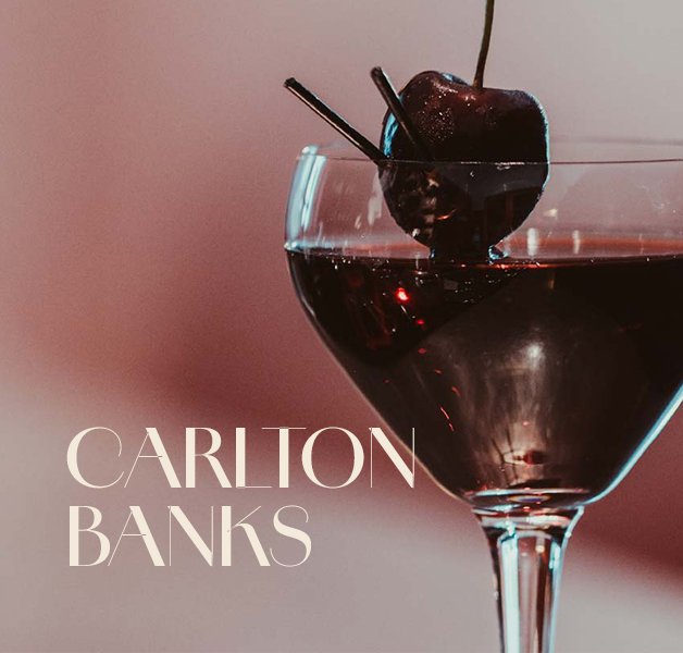 Glas mit ECKES Carlton Banks Cocktail, garniert mit einer dunklen Kirsche auf einem Zahnstocher