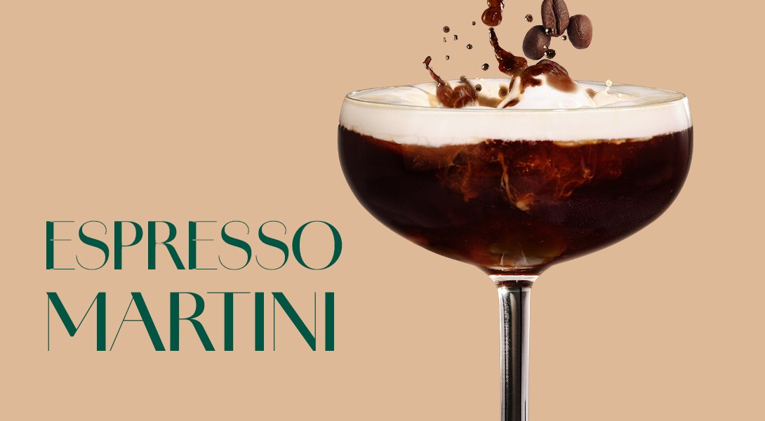 Glas mit dunkelbraunem Espresso Martini, garniert mit einer Schaumkrone und fallenden Kaffeebohnen.