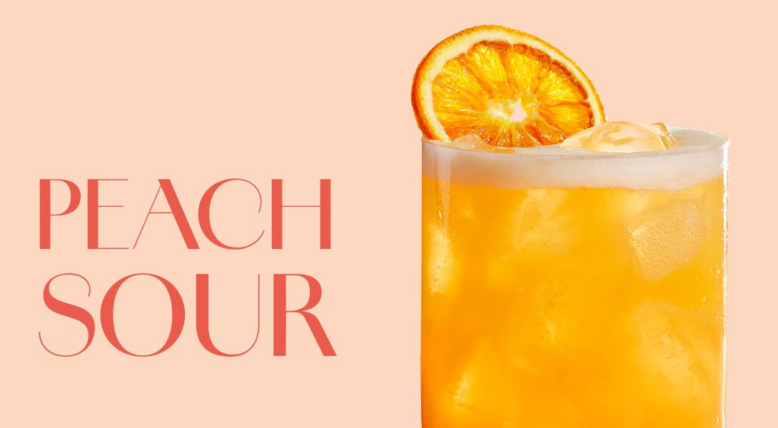 Säuerlicher Peach Sour Cocktail mit ECKES Weißer Pfirsich Likör, Zitronen- und Orangensaft, serviert auf Eis und garniert mit einer frischen Orangenscheibe.