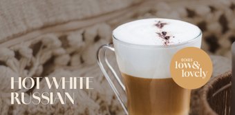Ein elegantes Glas mit einem heißen White Russian, gekrönt von einer cremigen Schicht und einem Hauch von Kakaopulver.