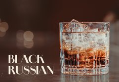 Ein Glas mit einem Black Russian Cocktail, gefüllt mit Eiswürfeln und einer dunklen Flüssigkeit, steht auf einer glänzenden Oberfläche.
