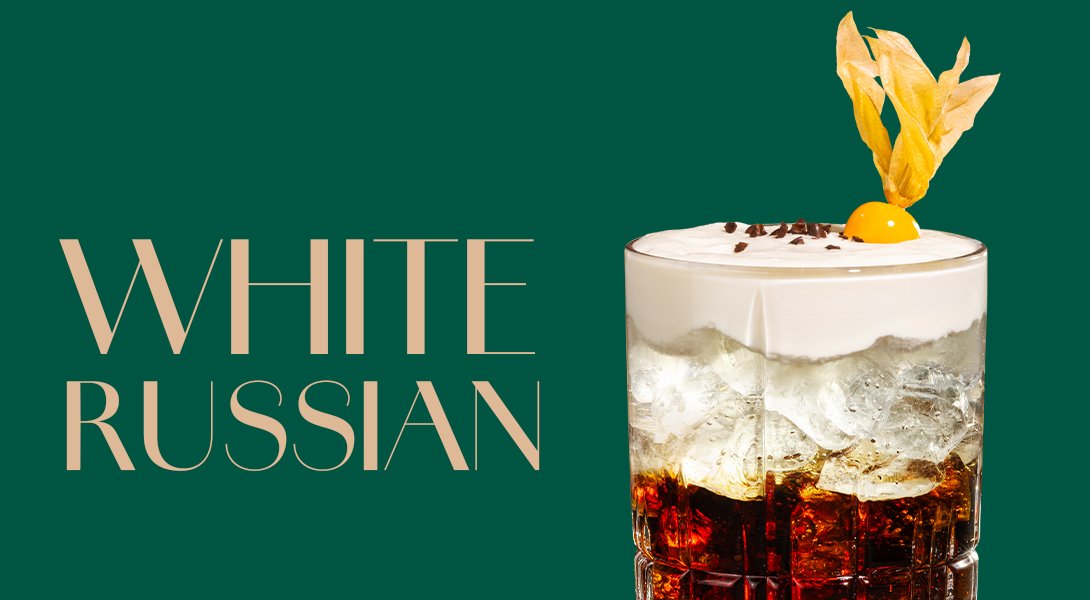 Glas mit White Russian Cocktail, gekrönt von einer Sahneschicht und einer Zitronenzeste.
