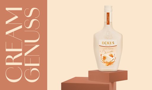 Eine elegante Flasche Eckes White Toffee Cream steht auf einem braunen Block, umgeben von einem sanften, hellen Hintergrund.