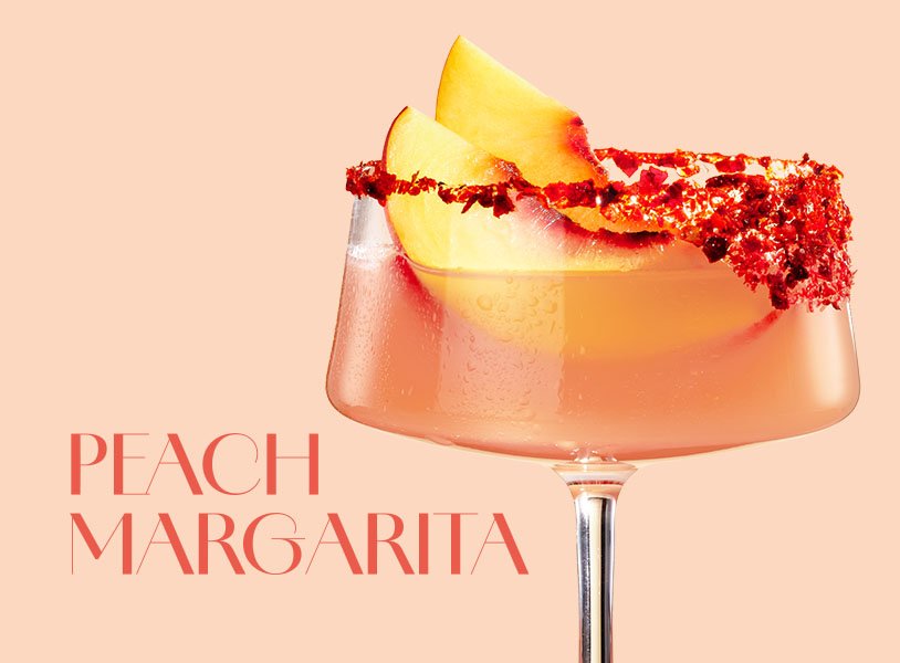 Fruchtige Peach Margarita mit ECKES Weißer Pfirsich Likör, Silver Tequila, Limettensaft und Crushed Ice, serviert in einer Cocktailschale mit Chili-Salzrand und garniert mit frischen Pfirsichscheiben.