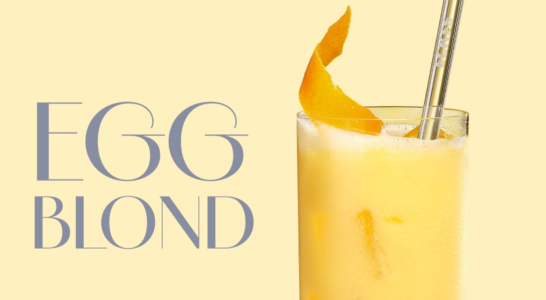 Glas mit gelbem Eierlikör-Cocktail Egg Blond, dekoriert mit einer Zitronenzeste