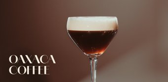 Ein elegantes Glas mit Oaxaca-Kaffee, das eine schaumige Schicht auf der dunklen Flüssigkeit zeigt.