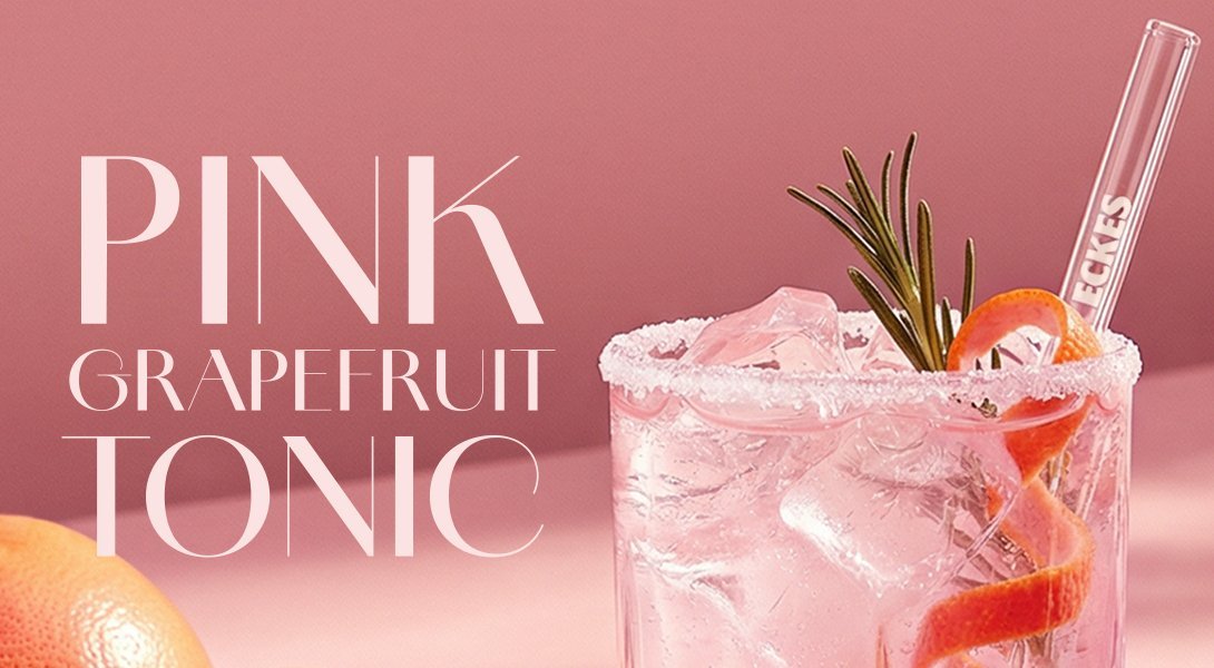 Ein erfrischendes Glas Pink Grapefruit Tonic mit Eiswürfeln, dekoriert mit einer Rosmarinnadel und einer Zitrusschale.