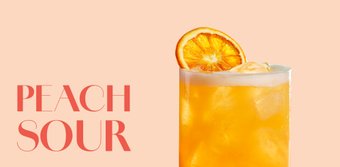 Ein erfrischendes Getränk in einem hohen Glas, gefüllt mit Eis und einer leuchtend orangefarbenen Flüssigkeit.