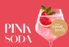 Elegantes Pink Soda im Glas mit Zitrusring, Erdbeere und Minzblättern als Garnitur auf rosafarbenem Untergrund.