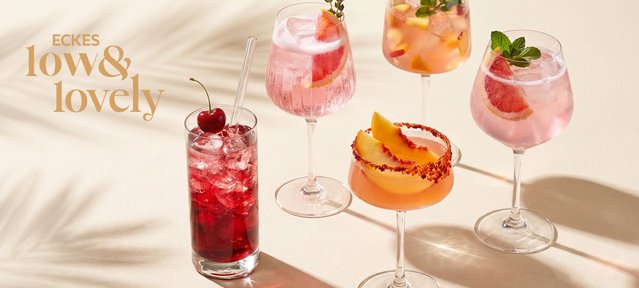 Acht unterschiedlich dekorierte Cocktails in verschiedenen Gläsern auf einem 
