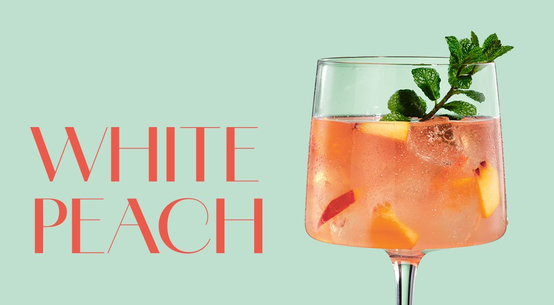 Erfrischender White Peach Cocktail mit ECKES Weißer Pfirsich Likör, Rosé Sekt und Bitter Lemon, garniert mit Minzblättern.