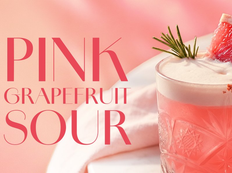 Ein erfrischender pinker Grapefruit-Cocktail in einem eleganten Glas, garniert mit einer Grapefruit-Scheibe und Rosmarin.