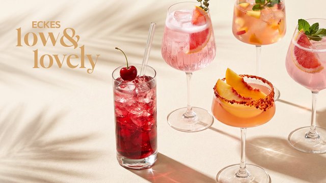 Acht unterschiedlich dekorierte Cocktails in verschiedenen Gläsern auf einem 